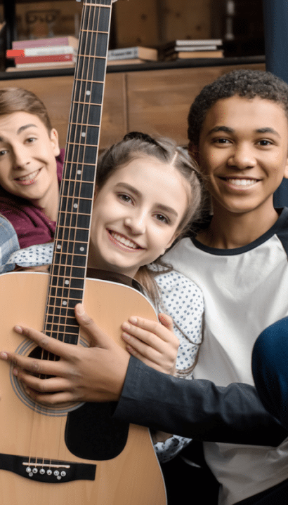 Teens hugging guitar