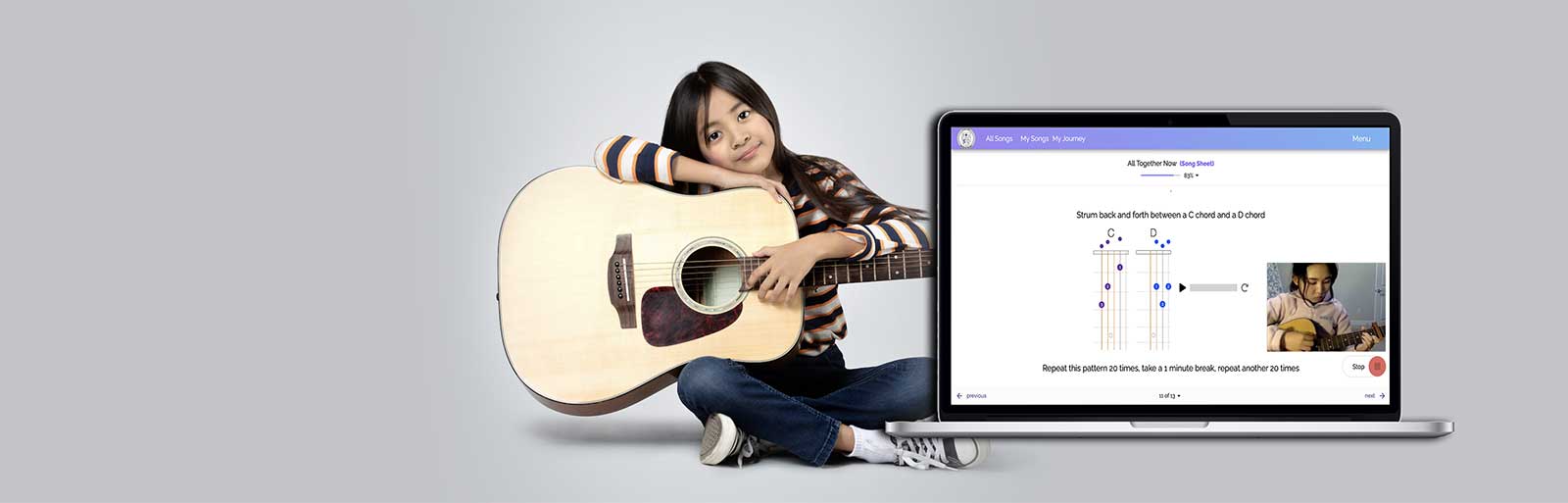 Girl playing acoustic guitar next to laptop showing the Moosiko lesson app